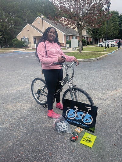 A photo of a girl with her bike.